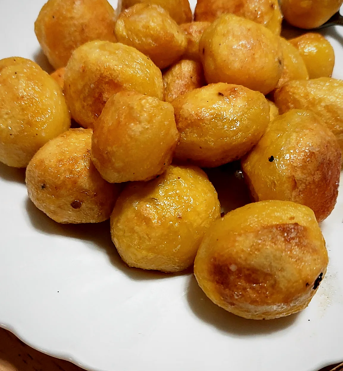 Golden roasted potatoes on a white plate
