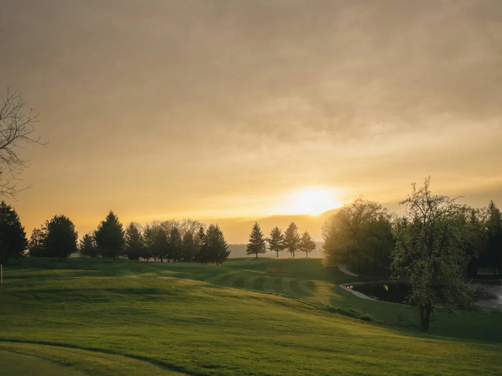 Golden evening light settling over a golf course fairway