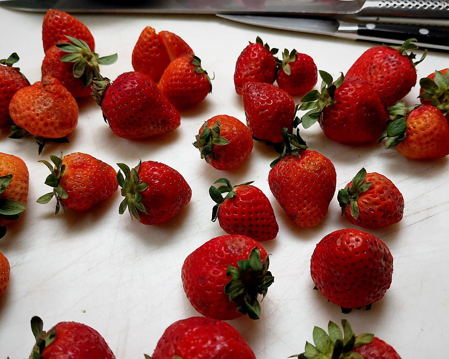 Fresh strawberries laid out on a cutting board
